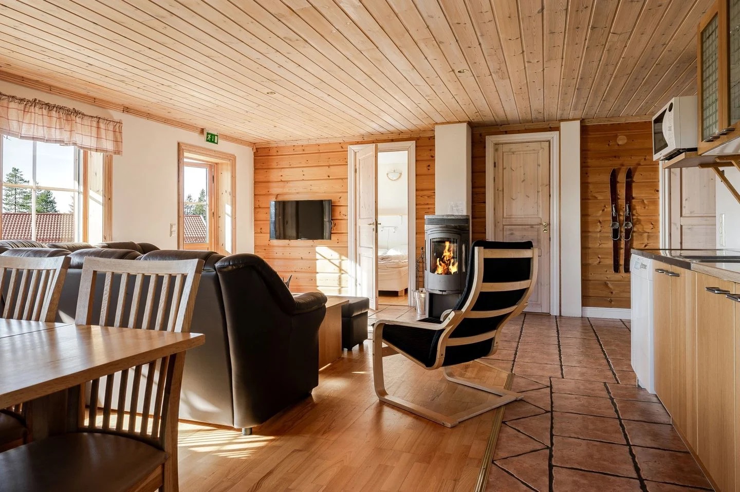 Storstuga med matplats, soffgrupp och braskamin